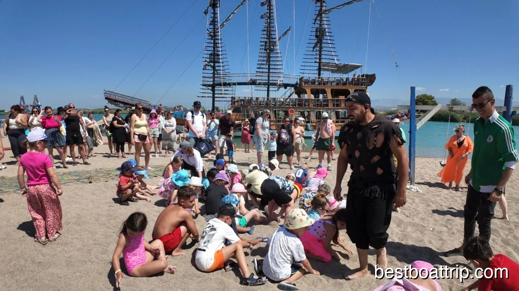 Pirate animator leading treasure hunt games with excited children on the beach