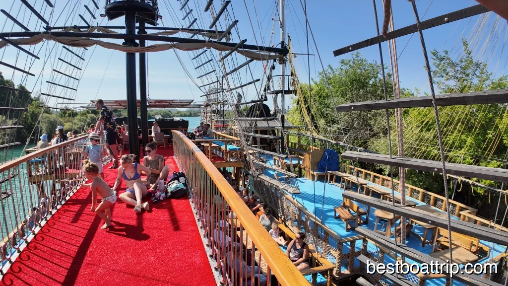 Families and children relaxing on the red carpet deck of the pirate ship